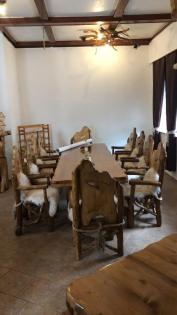 Rustikaler Tisch mit 10 Stühle die mit Lammfell belegt sind