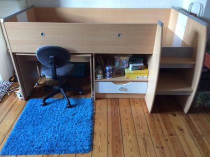 Kinderhochbett mit Schreibtisch mit Stuhl und blauen Teppich